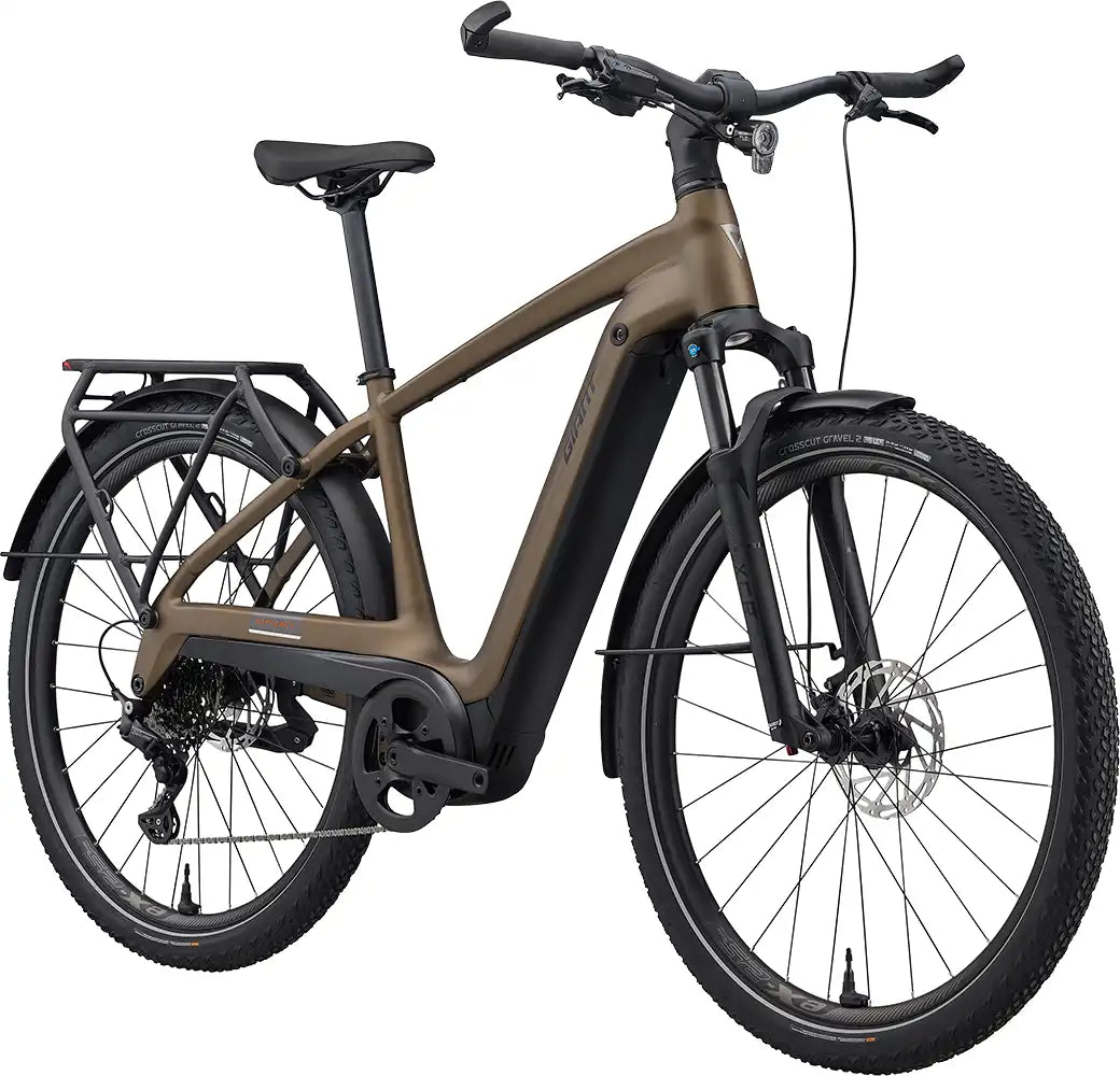 Front view of a 2026 Giant Explore E+ 3 electric bike in Pyrite Brown, showcasing its frame and front wheel.