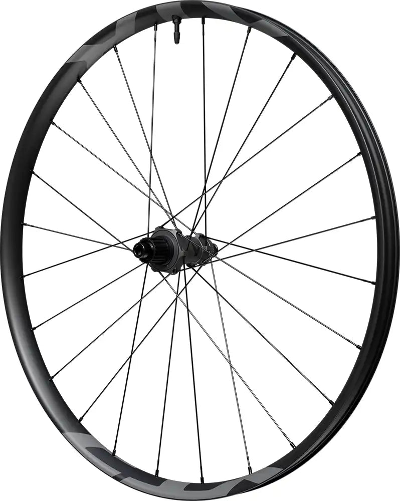 Shimano XTR XC M9200 carbon tubeless disc wheel with black rim and spokes, mounted on a mountain bike for off-road riding.