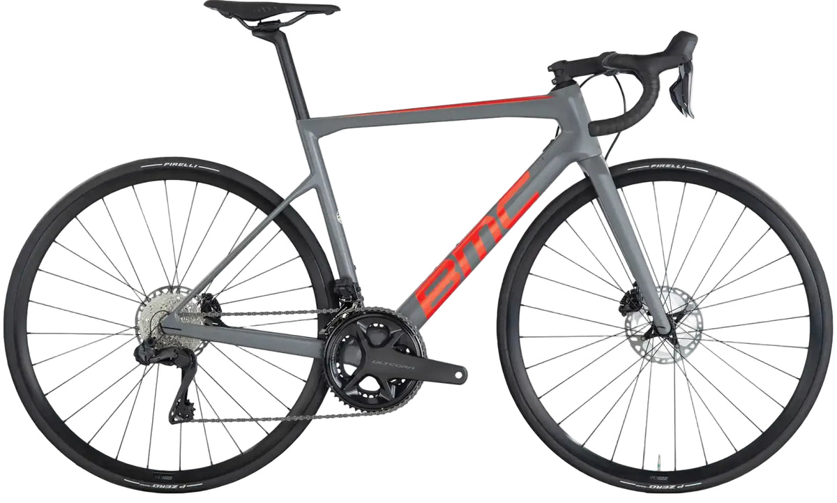 BMC Teammachine SLR TWO road bike with lightweight frame and sleek design, shown in black and red on a road background.