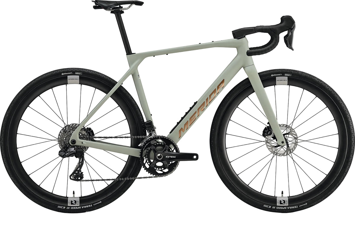 Gray Merida Mission 7000 gravel bike with lightweight frame and rugged tires, ready for off-road adventures.