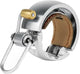 Knog Oi Luxe Silver small bike bell with sleek design and polished finish, mounted on a bicycle handlebar.