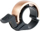 Knog Oi Classic Brass Bell, a small accessories bell with a brass finish and traditional design, mounted on a bicycle handlebar.
